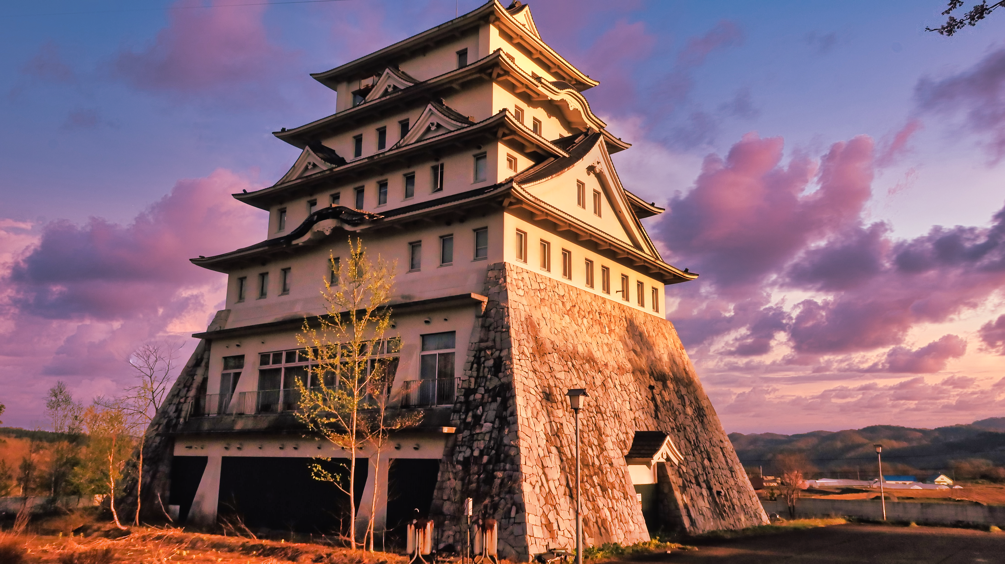 A side photo of Akabiratokugawa castle during sunset on a slightly overcast day.