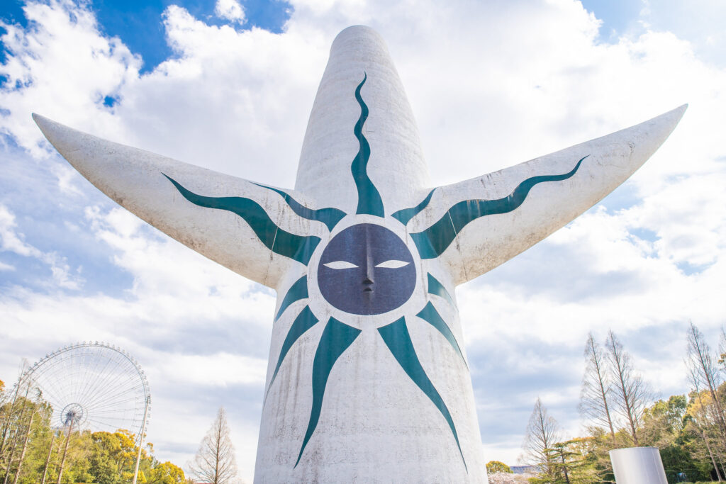 Photo of the back of the Tower of the Sun showing a black sun with a face, mouth and nose.