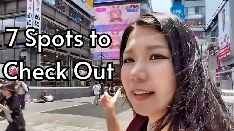 Hazu in the middle of Dotonbori bridge pointing towards the clubs and bars she's about to present.