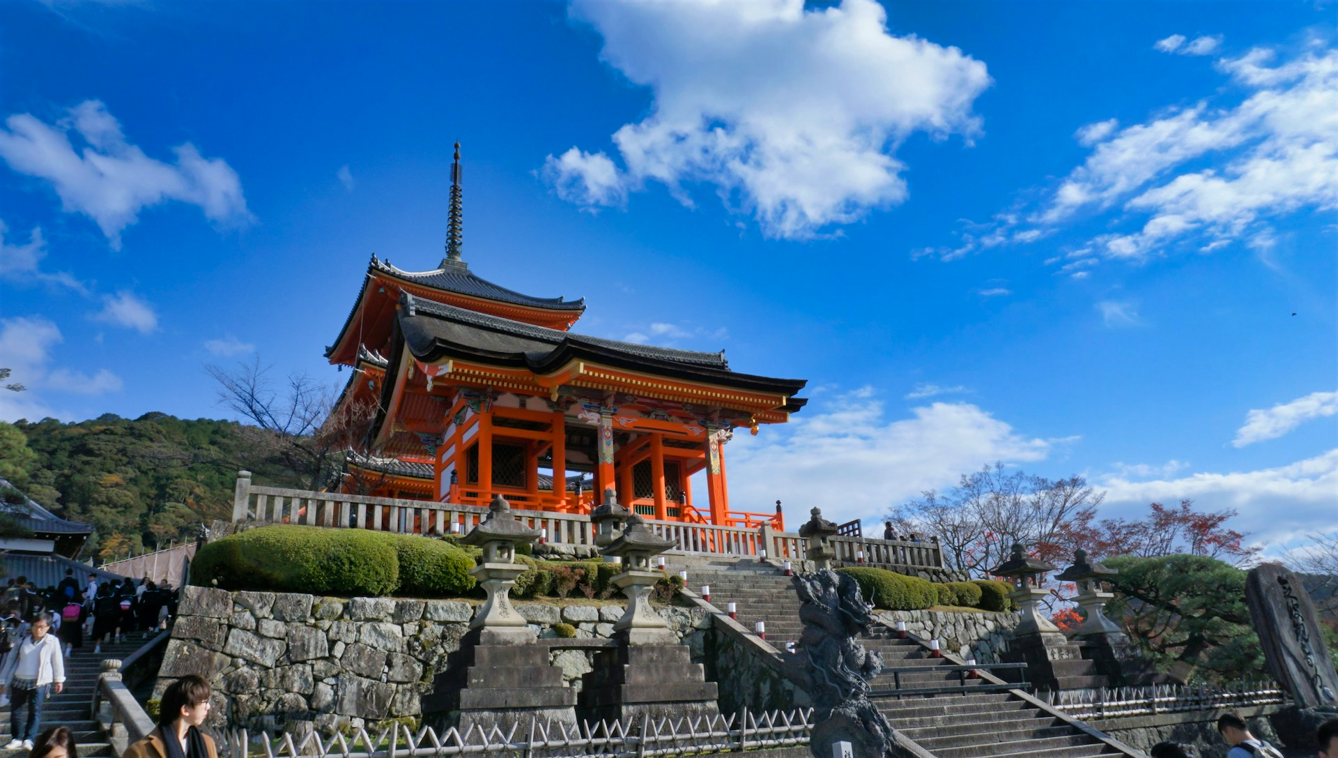 A view of the Kiyomizu-dera temple from the front-left side looking up towards the middle on a sunny day with clear skies.