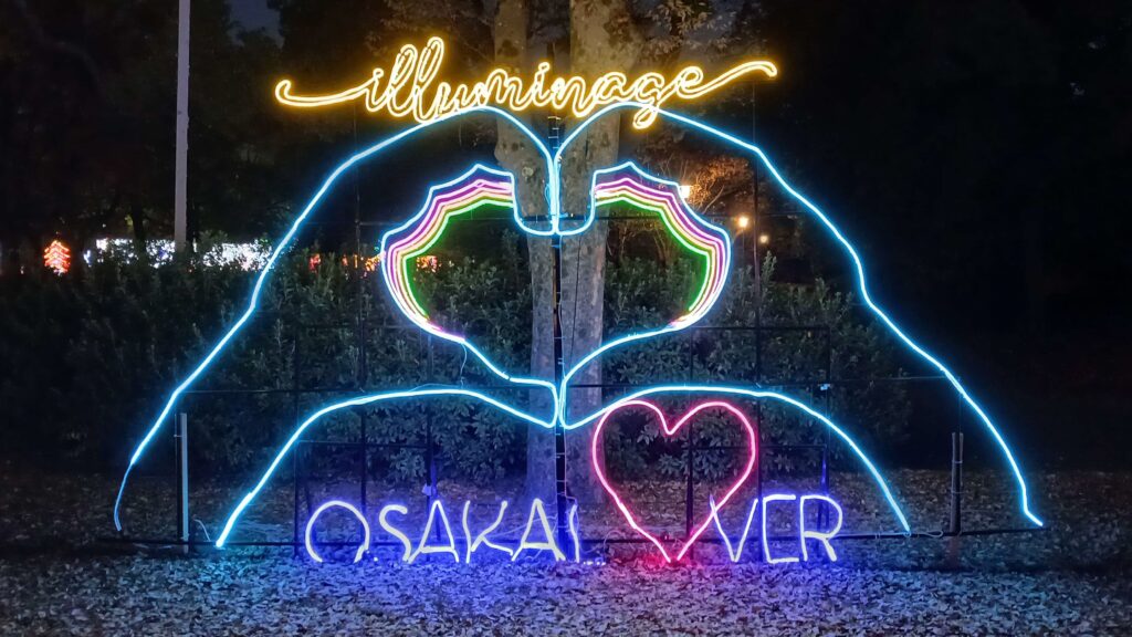 A sign with 2 hands making a heart and the words "Osaka lover" underneath