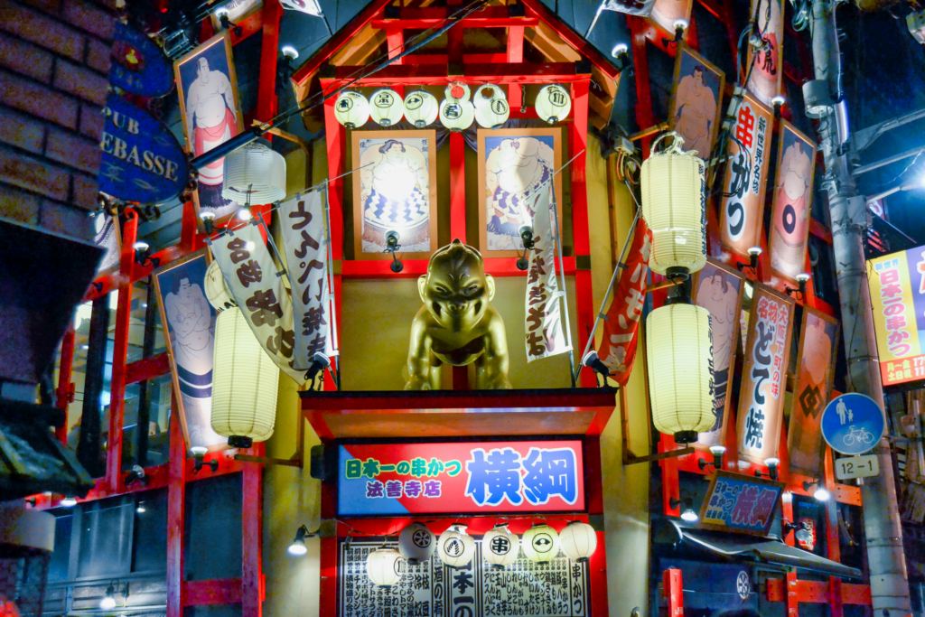 A Billiken Shrine in front of a building in Osaka.