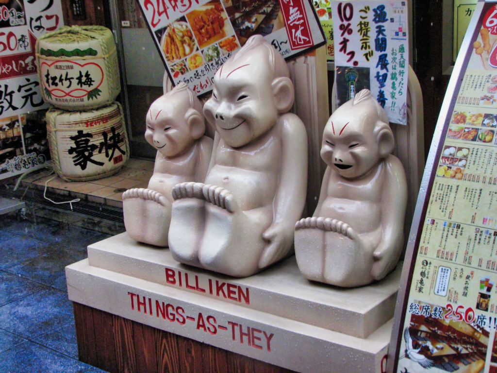 3 Billikens in front of an Izakaya in Osaka on a stand which uses it's iconic tagline "things as they".